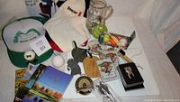 Full overview of lot items including towels, drink holder, bag tags, mug with tees, golf ball soaps, divot repair tool, and novelty golf ball