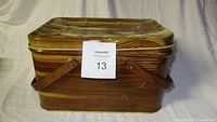 Closed vintage picnic basket with wood grain design and handles