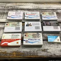 Top-down view of 8 cigarette tins arranged in two rows on a wooden surface with visible health warning labels and branding.