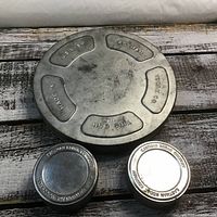 Top view of all three film canisters, showing embossed markings and wear