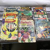 Overview shot of ten comics laid flat showing covers of Avengers, Spider-Man, Fantastic Four and Detective Comics