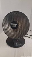 Front view of Holmes HeatSafe parabolic heater showing mesh grille and badge