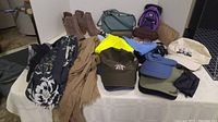 Overview of ladies' scarves, hats, half boots, and handbags arranged on a table