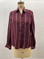 Front view of blouse on dress form showing button-up closure and vertical stripe pattern