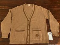 Full front view of camel hair cardigan laid flat showing overall condition and design