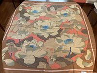 Full view of shawl laid flat showing overall lotus flower pattern and color palette