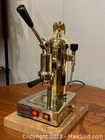 Angled front view showing lever handle, portafilter, steam wand, control panel with indicator lights