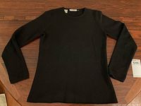 Front view of black cashmere sweater laid flat