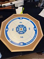 Top view of octagonal crokinole board with blue and white scoring zones and central hole for playing discs