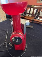 Front view of the red and silver Swirlio 1430BR Big Boss Fruit Ice Cream Machine with control panel and power cord visible.