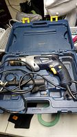 Blue hardsided case opened revealing the Mastercraft 1/2 inch hammer drill with power cord coiled inside.