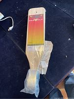 Full view of the RedWolf fish cleaning board still in plastic packaging, on a black surface.