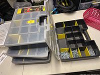 Four Stanley Sort Master cases stacked closed on a table next to one opened showing screws in compartments