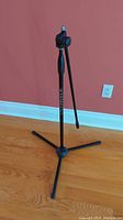 Full view of black Ultimate Support microphone tripod stand showing tripod base and adjustable shaft.