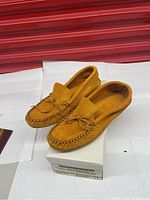 Pair of tan suede men's moccasins size 11 displayed on a box, showing top, side, and toe details.