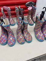 6 pairs of girls rain boots standing upright on white surface showing front and side views