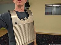 Person wearing the metal Zydeco washboard on chest showing size and design