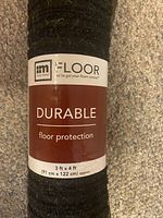 Close-up photo of rolled floor mat with label showing size 3 ft x 4 ft and brand Multy Home