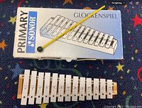 SONOR Primary series glockenspiel with 16 white metal keys on wooden frame, yellow mallet, and original box.