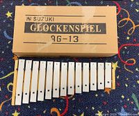 Main diatonic set of 13 aluminum bars labeled C to A with Suzuki Glockenspiel AG-13 cardboard box