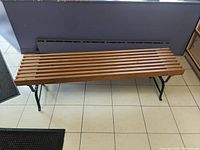 Top view of wooden bench showing slatted wood seat and metal legs.