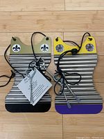 Photo of two mini zydeco rubboards showing color, decoration and accessories like metal keys and leather thongs.