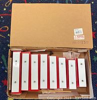 Photo of 8 resonator bells packed inside an open box with label RB-2123 visible on the top flap.