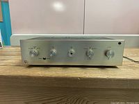 Front view showing brushed aluminum panel and control knobs