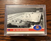 Front of first card in set labeled 'In The Beginning' with hockey image