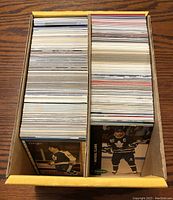 View from above showing two stacks of assorted Toronto Maple Leafs hockey cards in a yellow storage box.