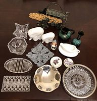 Overhead image showing all 16 assorted glass dishes, ceramic pitchers, salt and pepper shakers, small figurines, and metal grape basket.
