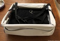 Dog/pet car seat, beige with black straps and soft black interior, displayed from the top