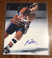 Color 8x10 photo of Guy Lafleur skating, signed in blue ink.