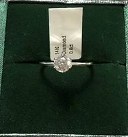 Front view of ring in velvet display box with tag indicating 14Kt, Diamond, 0.8ct