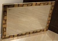 Full view of the rectangular mirror showing the gold and bronze coloured frame and bevelled glass surface