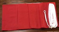 The folded Canadian flag with visible red and white parts and attached rope.
