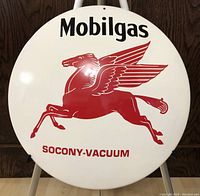 Front view showing round Mobilgas metal advertising button with red Pegasus and text 'SOCONY-VACUUM'