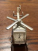 Front view showing helicopter main rotor and clock face marked Logic Quartz with black numerals.