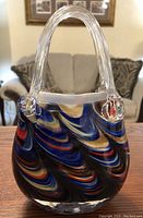 Front view showing swirled blue, red and gold pattern with clear handles