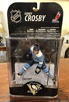 Front view of the Sidney Crosby figurine in original sealed packaging showing NHL and player name branding.