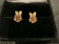 Pair of 10K gold flower earrings displayed in a black velvet box, showing detailed flower design with two leaves per earring.