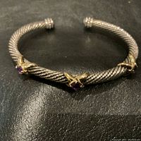 Front view of the sterling silver twisted cable cuff bracelet with three amethyst stones in 14K gold mounts.