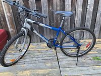 Full side view of adult mountain bike showing the frame, tires, handlebars, and seat.