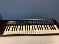 Front view of Casio CA-110 ToneBank keyboard showing control panel with sliders and buttons above white and black keys.