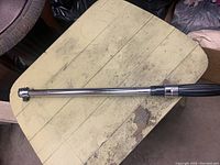 Full length image of chrome Mastercraft torque wrench resting on wood surface showing overall size and shape.