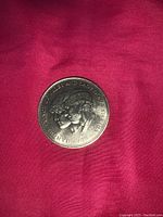 Front side of the large commemorative coin showing profiles of Prince Charles and Lady Diana with inscription around edge.