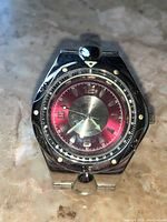 Close-up front view of the Qboz men's stainless steel wristwatch showing the red and silver dial, luminous markers and bezel.