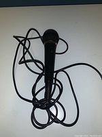 Sony F-V220 microphone photo showing microphone and tangled attached cable on a white surface taken from above.