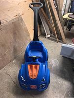Front view of the blue Step 2 Hot Wheels child push car with black handle and orange hood detail showing condition and overall appearance.