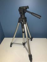 Full view of the tripod showing the aluminum legs and black handle with level reader.